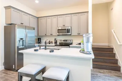 a kitchen with a sink and a refrigerator at Bright & Airy Cottage Near Disney With Margaritaville Resort & Island H2O Access - 8008Ls in Orlando