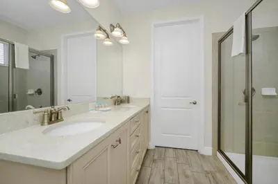 a white bathroom with a sink and a shower at Dreamy Cottage Near Disney With Margaritaville Resort & Island H2O Access - 8069Kd in Orlando