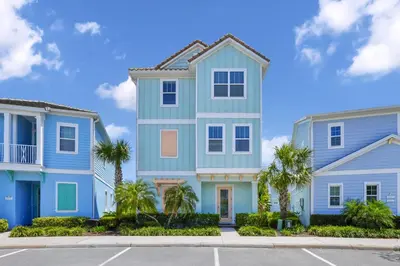 a blue house with palm trees in a parking lot at Dreamy Cottage Near Disney With Margaritaville Resort & Island H2O Access - 8069Kd in Orlando