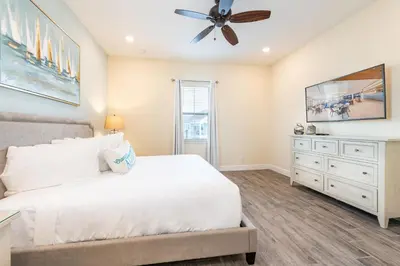 a bedroom with a white bed and a ceiling fan at Paradise Cottage Near Disney With Margaritaville Resort & Island H20 Access - 8137Su in Orlando