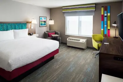 a hotel room with a bed and a desk and chair at Hampton Inn Kissimmee North in Kissimmee