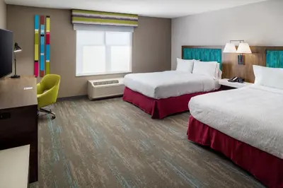 a hotel room with two beds and a window at Hampton Inn Kissimmee North in Kissimmee