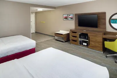a hotel room with a bed and a flat screen tv at Hampton Inn Kissimmee North in Kissimmee