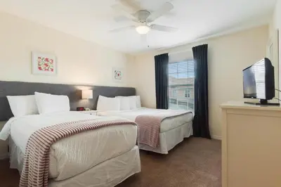 a hotel room with two beds and a flat screen tv at Townhome w pool near Disney & Orlando Attractions in Kissimmee