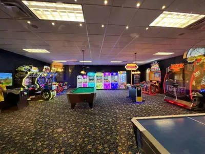 a room with several arcade games and a pool table at Townhome w pool near Disney & Orlando Attractions in Kissimmee