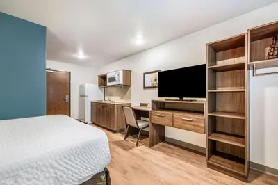 a bedroom with a bed and a desk with a television at Extended Stay America Select Suites - Orlando - Kissimmee in Orlando