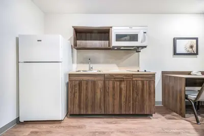a kitchen with a white refrigerator and a microwave at Extended Stay America Select Suites - Orlando - Kissimmee in Orlando