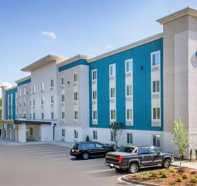 a large building with cars parked in a parking lot at Extended Stay America Select Suites - Orlando - Kissimmee in Orlando