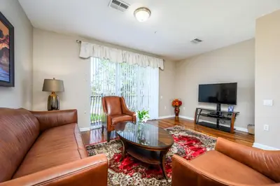 a living room with a couch and a table and a tv at Gorgeous Vista Cay Town Home, Vista Cay - 4002 in Orlando