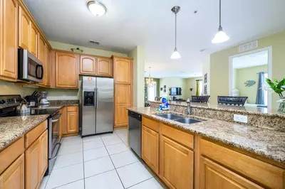 a large kitchen with wooden cabinets and stainless steel appliances at Premium Lake View Condo, Vista Cay - 1005 in Orlando
