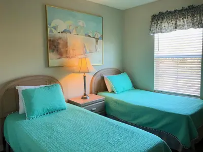 a bedroom with two beds and a lamp and a window at Gated Emerald island resort townhome, Overlook Pool, 3 miles to Disney, rent by owner in Kissimmee