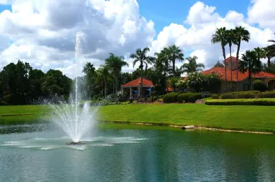 a fountain in a pond in front of a house at Gated Emerald island resort townhome, Overlook Pool, 3 miles to Disney, rent by owner in Kissimmee