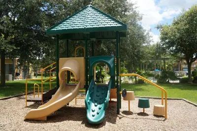 a playground with a slide in a park at Gated Emerald island resort townhome, Overlook Pool, 3 miles to Disney, rent by owner in Kissimmee