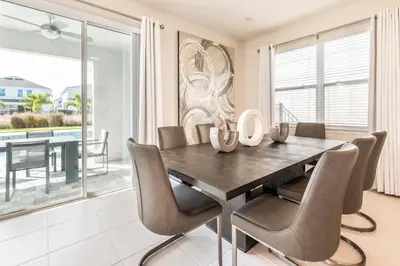a dining room with a table and chairs at Elegant Home Near Disney With Private Pool, Foosball Table, Themed Rooms And Waterpark & Resort Access At Encore Resorts Reunion - 365Sf in Kissimmee
