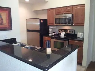a kitchen with a black counter top and a refrigerator at Luxury Resort Condo, 2 or 3 BR, Premium suites in Orlando