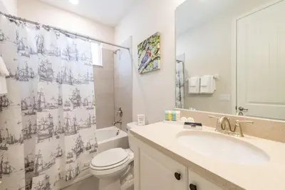 a bathroom with a toilet sink and a shower curtain at Spacious Home With Game Room, Private Pool And Waterpark & Resort Access Near Disney At Encore Resorts Reunion - 241Sf in Kissimmee