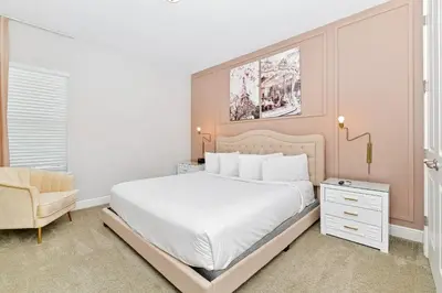 a bedroom with a white bed and a chair at Modern Home Near Disney With Private Pool, Media, Game & Themed Rooms With Waterpark & Resort Access At Encore Resorts Reunion - 384Sf in Kissimmee
