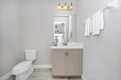 a white bathroom with a toilet and a sink at Grand Home Near Disney With Private Pool, Air Hockey Table And Waterpark & Resort Access At Encore Resorts Reunion - 401Sf in Kissimmee