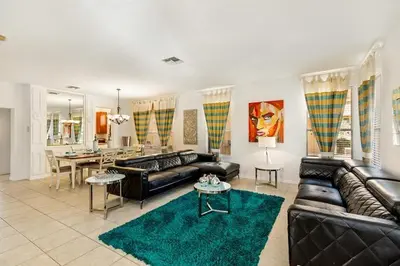 a living room with leather couches and a dining room at Lakeview 6-Bedroom Retreat with Game Room, Private Pool, Spa & Resort Amenities - Ideal for Families & Groups in Kissimmee
