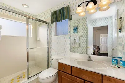 a bathroom with a toilet and a sink and a shower at Lakeview 6-Bedroom Retreat with Game Room, Private Pool, Spa & Resort Amenities - Ideal for Families & Groups in Kissimmee