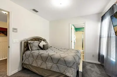 a bedroom with a bed in a room at Lakeview 6-Bedroom Retreat with Game Room, Private Pool, Spa & Resort Amenities - Ideal for Families & Groups in Kissimmee
