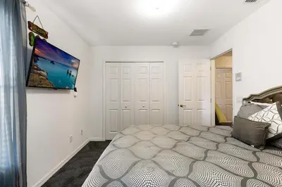 a bedroom with a bed and a painting on the wall at Lakeview 6-Bedroom Retreat with Game Room, Private Pool, Spa & Resort Amenities - Ideal for Families & Groups in Kissimmee