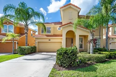 a large house with palm trees and a driveway at Lakeview 6-Bedroom Retreat with Game Room, Private Pool, Spa & Resort Amenities - Ideal for Families & Groups in Kissimmee