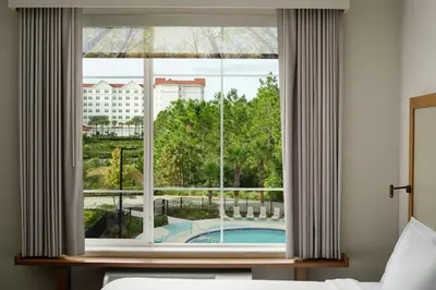 a bedroom with a window with a view of a pool at Fairfield by Marriott Inn & Suites Orlando at FLAMINGO CROSSINGS® Town Center in Orlando