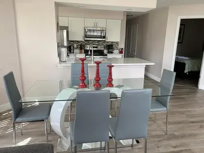 a glass table with four red vases on it in a kitchen at Grand Family Premium 3BR Condo near Disney Parks in Kissimmee