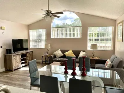 a living room with a table and a couch at Grand Family Premium 3BR Condo near Disney Parks in Kissimmee
