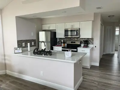 a kitchen with white cabinets and a counter top at Grand Family Premium 3BR Condo near Disney Parks in Kissimmee