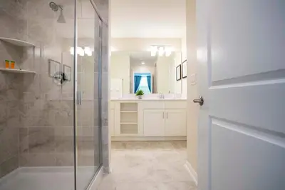 a bathroom with a shower with a glass door at Luxurious 2 Bd Close to Disney @ Storey Lake 204P in Kissimmee
