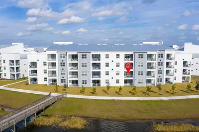 a large white apartment building with a body of water at Luxurious 2 Bd Close to Disney @ Storey Lake 204P in Kissimmee
