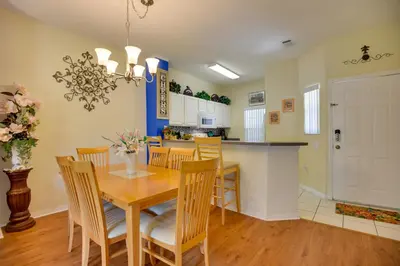 a kitchen and dining room with a wooden table and chairs at Near Disney and Epic Universe Home with Resort Perks in Kissimmee