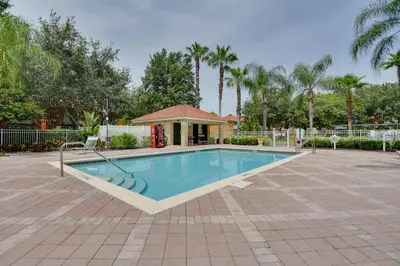 a swimming pool with a gazebo and palm trees at Near Disney and Epic Universe Home with Resort Perks in Kissimmee