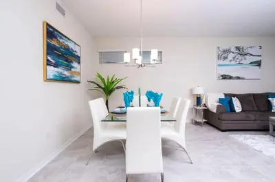 a dining room and living room with a table and chairs at Stunning 3Bd Apto Close to Disney 201P in Kissimmee