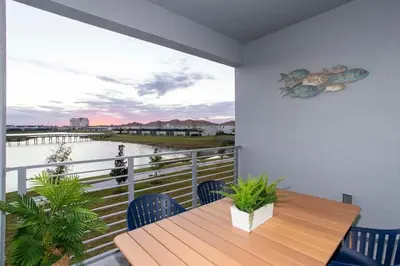 a balcony with a wooden table and a view of the water at Stunning 3Bd Apto Close to Disney 201P in Kissimmee