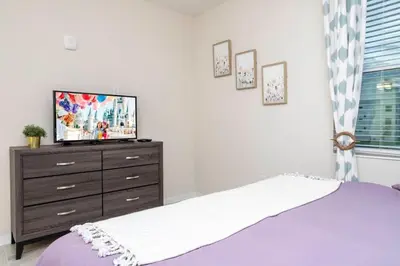 a bedroom with a bed and a tv on a dresser at Stunning 3Bd Apto Close to Disney 201P in Kissimmee