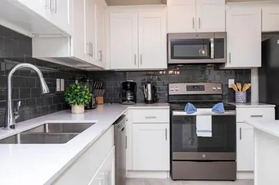 a kitchen with white cabinets and a stove top oven at Stunning 3Bd Apto Close to Disney 201P in Kissimmee