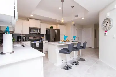 a kitchen with white cabinets and black appliances at Stunning 3Bd Apto Close to Disney 201P in Kissimmee
