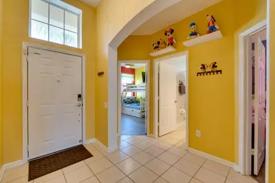 a hallway with yellow walls and a white door at Pool, Themed Rooms and Arcade Disney Escape in Kissimmee