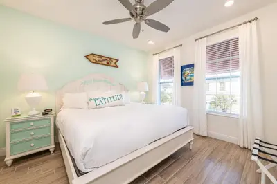 a white bedroom with a bed and a ceiling fan at Sunset On Shaker Cottage With Private Pool Near Disney With Margaritaville Resort & Island H20 Access - 7960Sh in Orlando