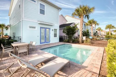 a house with a swimming pool and a table and chairs at Cocktails & Dreams Cottage With Private Pool Near Disney With Margaritaville Resort & Island H2O Access - 8005St in Orlando