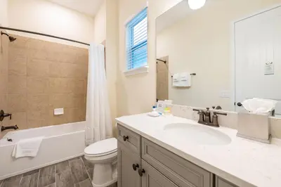 a bathroom with a sink and a toilet and a mirror at Cocktails & Dreams Cottage With Private Pool Near Disney With Margaritaville Resort & Island H2O Access - 8005St in Orlando