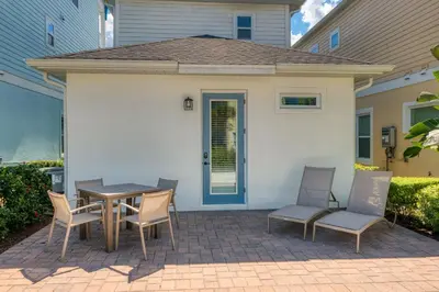 a patio with a table and chairs in front of a house at Comfy Cottage Near Disney With Margaritaville Resort & Island H2O Access - 8087Kd in Orlando