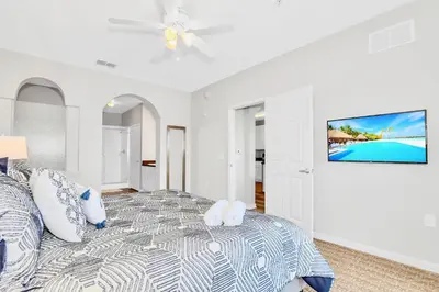 a bedroom with a bed and a tv on a wall at Spacious 3BR Near Disney - Pool in Orlando