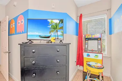 a bedroom with a black dresser with a television on it at Bright & Airy 3BR Suite Near Disney - Pool in Orlando