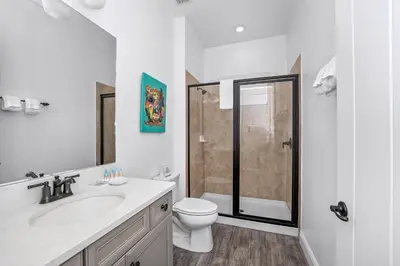a white bathroom with a toilet and a shower at Pineapple Dream Cottage With Private Hot Tub Near Disney With Margaritaville Resort & Island H2O Access - 8000Sb in Orlando