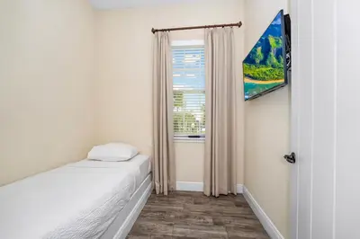 a small bedroom with a bed and a window at Pineapple Dream Cottage With Private Hot Tub Near Disney With Margaritaville Resort & Island H2O Access - 8000Sb in Orlando