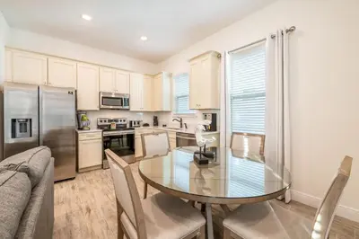 a kitchen with a glass table and chairs in a room at Inviting Cottage Near Disney With Margaritaville Resort & Island H2O Access - 8009St in Orlando
